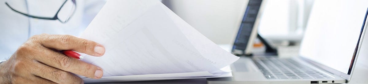 närbild av en persons hand som håller i en bunt papper